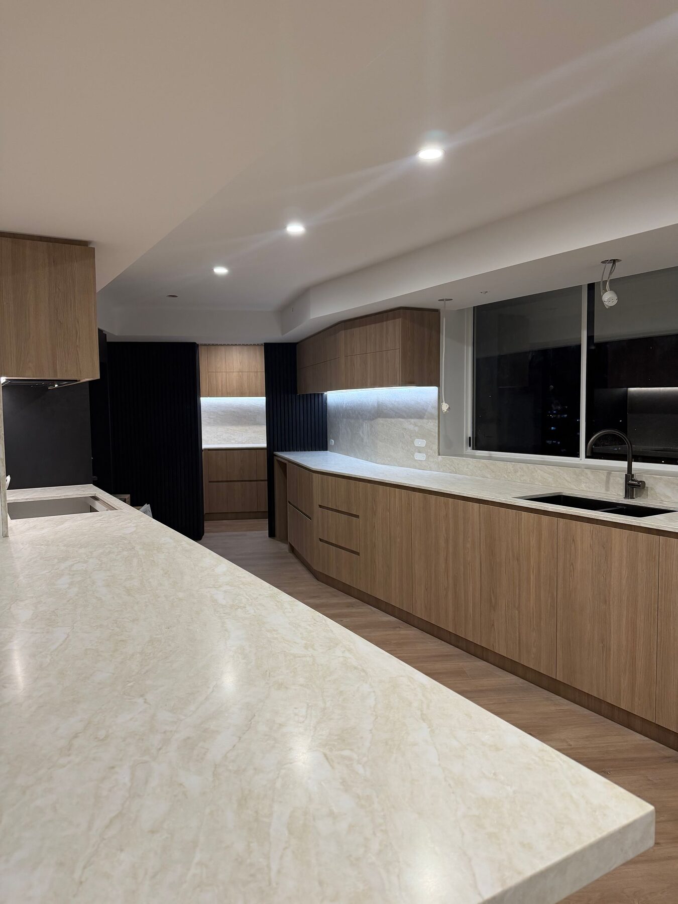 Renovated kitchen with stone island bench and integrated joinery